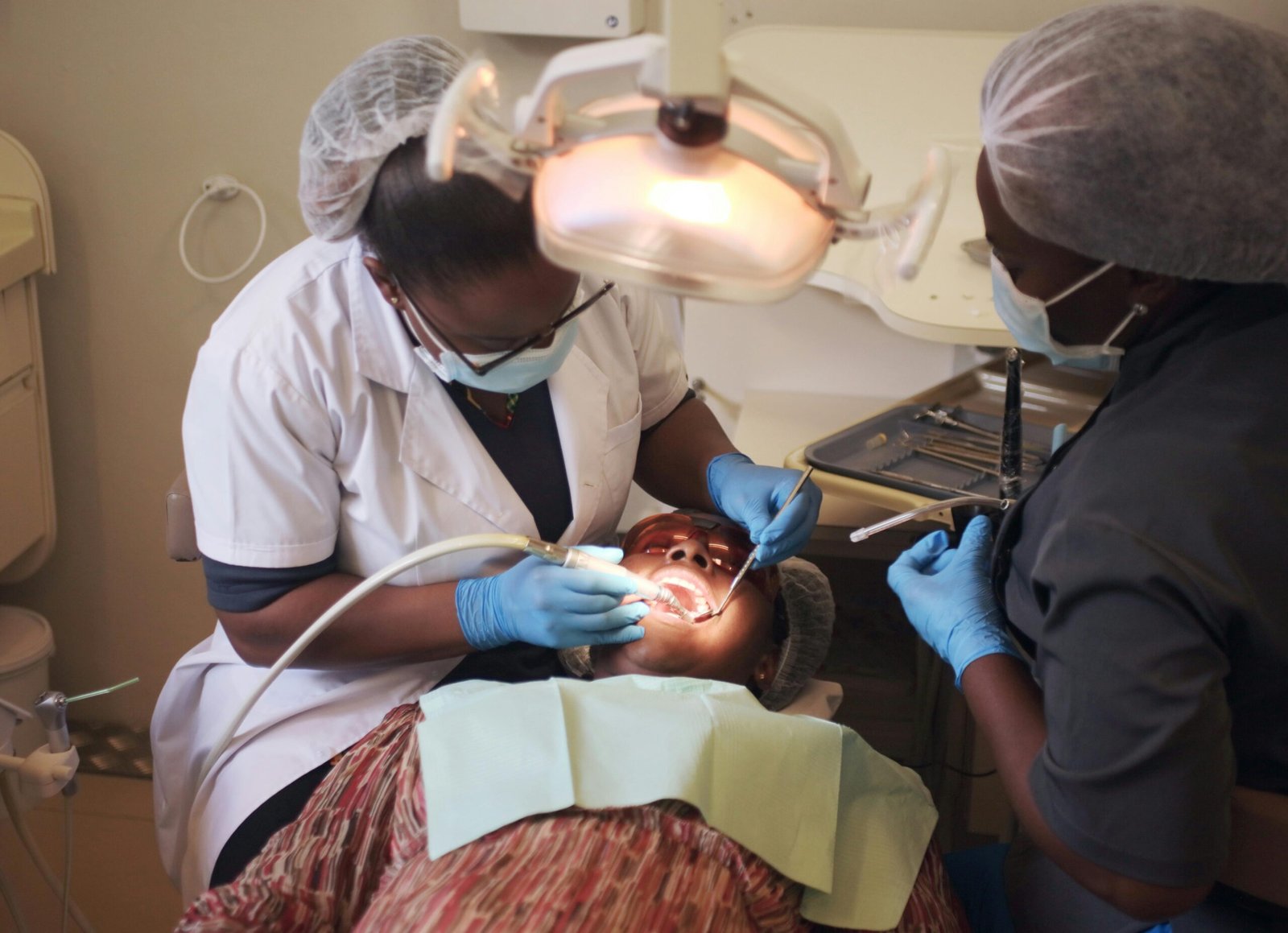 A dental procedure being performed by professionals in a clinic setting.